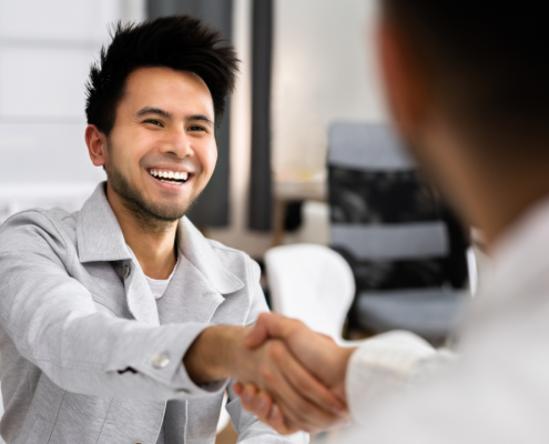 smiling business owner shaking hands with lender