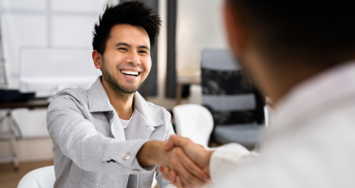 smiling business owner shaking hands with lender