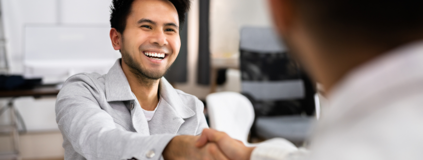 smiling business owner shaking hands with lender