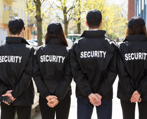 four security guards standing with their faces turned away